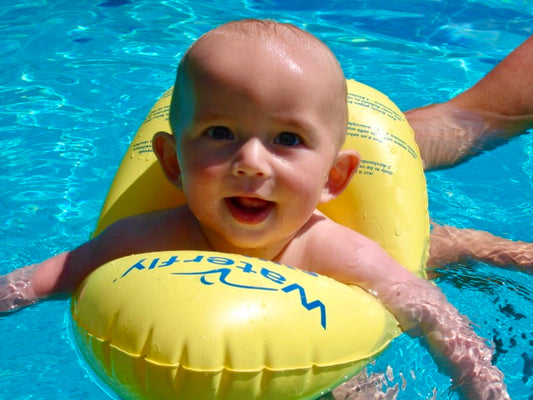 Baby sitzt in der Baby-Schwimmhilfe Swimi