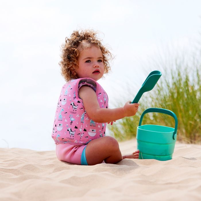 Mädchen am Strand trägt Kinder Schwimmweste Nina's Ark