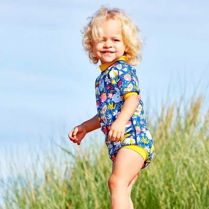 Mädchen am Strand trägt den Wetsuit "Garden Delight" mit LSF 50+