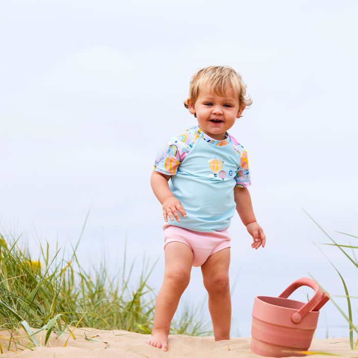 Mädchen trägt das UV Shirt "Up and Away" am Strand