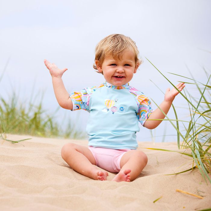 Mädchen trägt das UV Shirt "Up and Away" am Strand