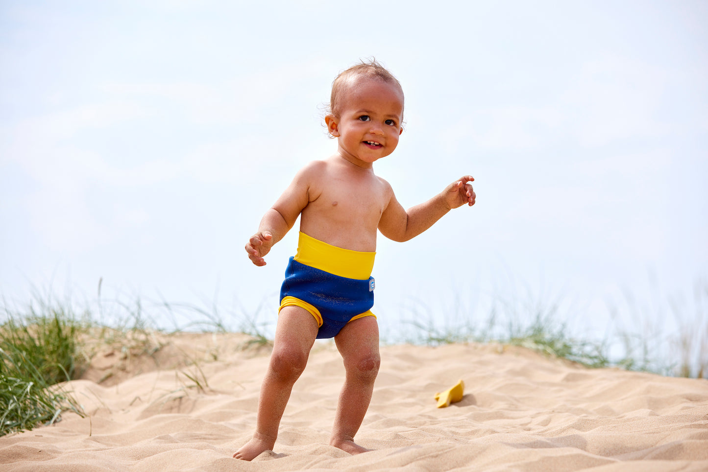 Kind mit Schwimmwindel am Strand