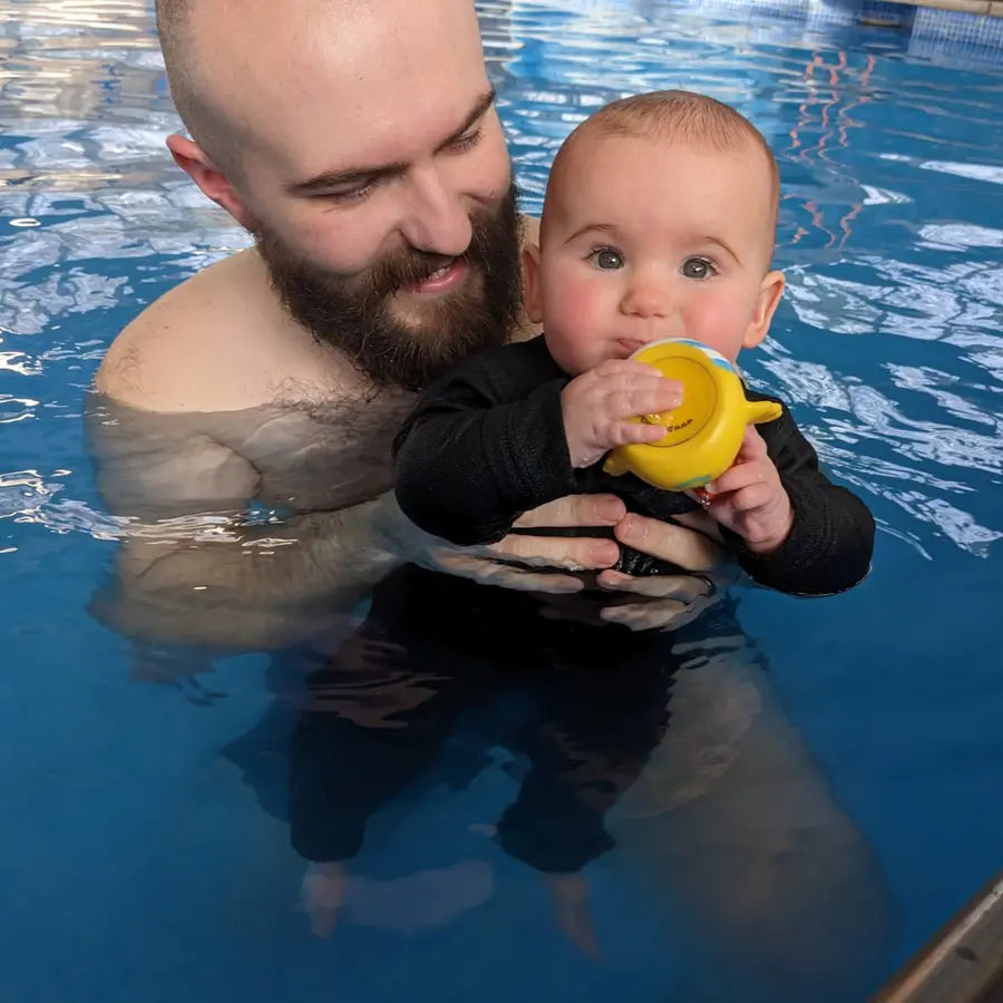 Baby mit Neoprenanzug im Wasser