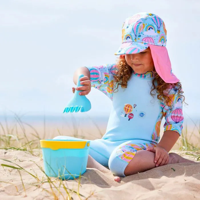 Mädchen am Strand trägt UV Schutzkleidung mit Sonnenhut und Schwimmanzug "Up and Away"