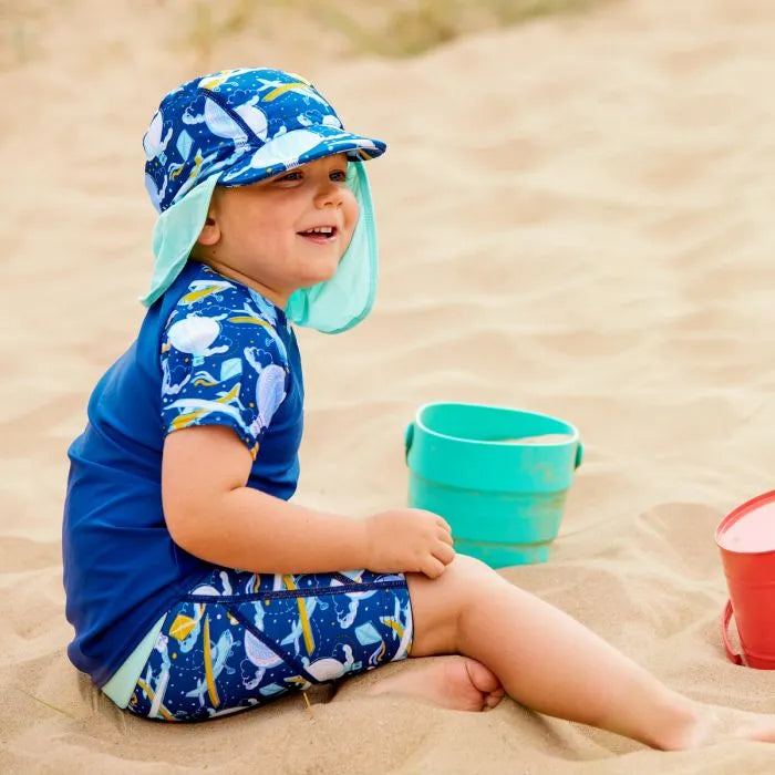 Junge spielt am Strand und trägt den UV Sonnenhut "Up in the Air"
