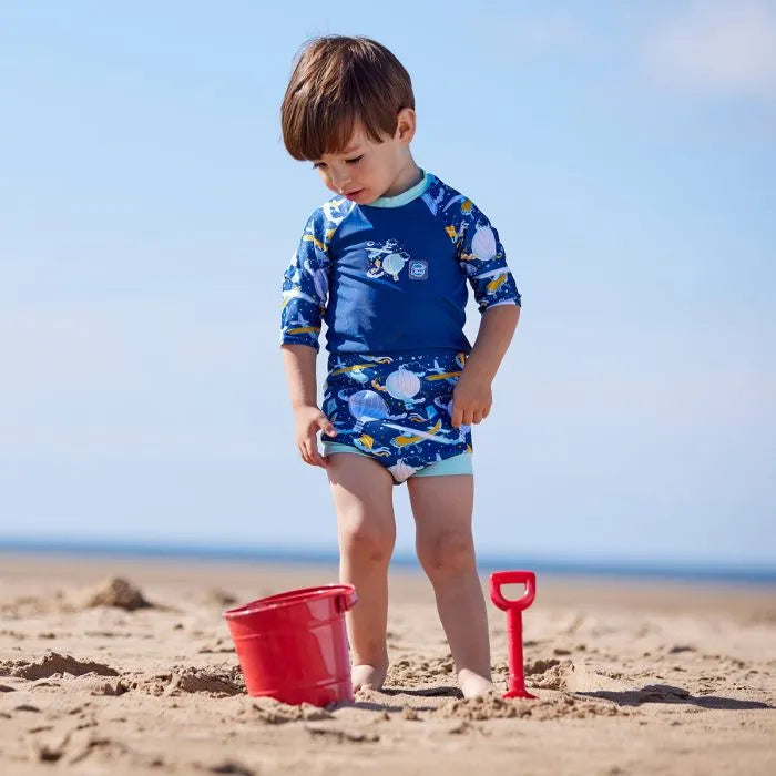 Junge am Strand trägt den UV Schwimmanzug "Up in the Air" mit LSF 50+