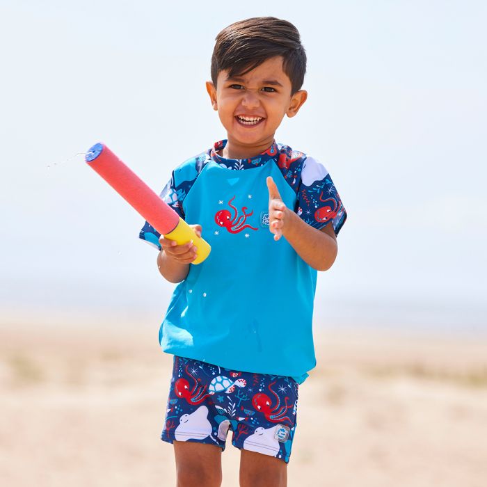Junge spielt am Strand und trägt das UV Shirt "Under the Sea"