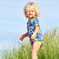 Mädchen am Strand trägt den Wetsuit "Garden Delight" mit LSF 50+