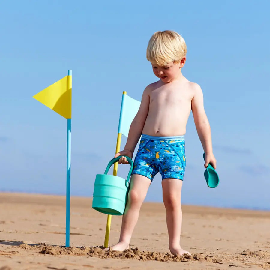 Junge am Strand trägt die Badehose mit UV Schutz