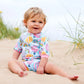Mädchen am Strand trägt den Wetsuit "Up and Away" mit Sonnenschutzfaktor 50+